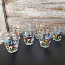 Vintage circa 1970s shot glasses. 7 glasses, 3 designs. 2 hunting scenes, 4 Welsh traditional lady, 1 green floral. Gold rims.