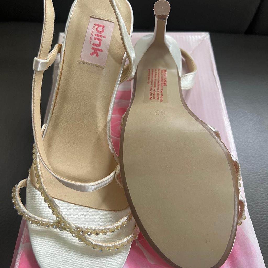 New shoes still in box. These beautiful ladies wedding shoes come in a UK size 5 and are perfect for any special occasion. The Pink brand has designed them with a chic slingback style and made them from high-quality synthetic materials in a lovely cream color. The shoes are fitted with heels that will not only make you stand tall but keep you comfortable throughout the day. These shoes are ideal for women looking for an elegant footwear collection to complement their outfit.