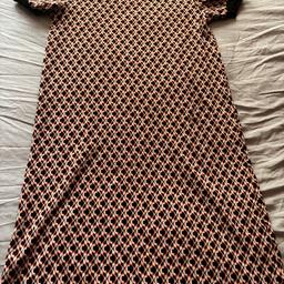 Size 10 primark dress only worn a couple of times. The dress has a pattern through it and the main colours are orange, black and white. It has a black ringed neckline and black rings on the sleeves