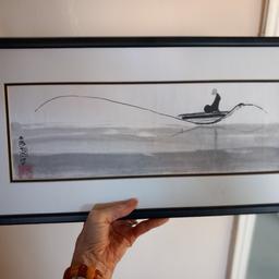 watercolour painting, monk fishing on the river.  Painting has a black frame.