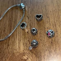 19cm Pandora bracelet 
Heart charm 
Charm with flowers on with bits of pink 
Four leaf clover charm 
I love you charm
Infinity charm