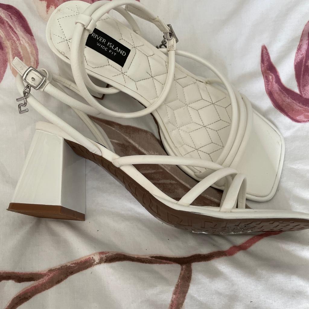 Worn once. Lovely condition. White straps sandals with ankle fastening. RI charm hanging from ankle strap. Chunky heel. Wide fitting. Size 6