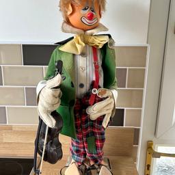 Clown figurine wearing a green jacket, carrying a violin. Has a flat base so is free standing. Nothing wrong with it, has just been stood on display for years. Very rare and cool item, don’t see pieces like these being sold any more. 

Measures approx 63cm (H)