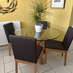 Circular glass table with oak pedestal and four charcoal grey upholstered chairs with oak legs from John Lewis.
Diameter of table is 110cm