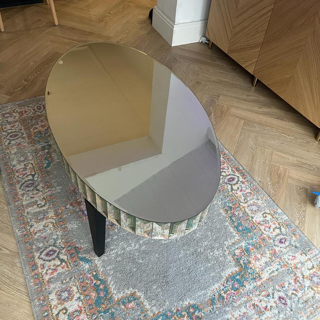 glass coffee table with dark wood legs with cur glass edging