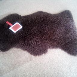 brown sheepskin rug from dunhelm. with brush. 39" X 23".