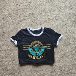 Boohoo
Black. White
Maryland University 
Short Sleeve
Crop Top
T shirt
Size UK 8
