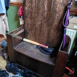 several hooks, mirror and storage in the bench