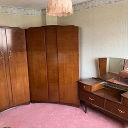 Mid Century Harry Lebus Bedroom Suite.
Includes two large wardrobes and a dressing table with mirror.

There is wear to the furniture, please look into the pictures.
Both wardrobes are lockable and are supplied with 4 keys. Could be polished up and look really nice in someone’s bedroom.

Dimensions -
Wardrobe one- W- 875mm D- 475mm. H-1760mm

Wardrobe two- W-1180mm D-475mm. H-1760mm

Dressing table- W-1270mm D-435mm
To height of drawers - 650mm. Height of mirror- 480mm

I can help move the furniture.
Can sell separately if wanted.