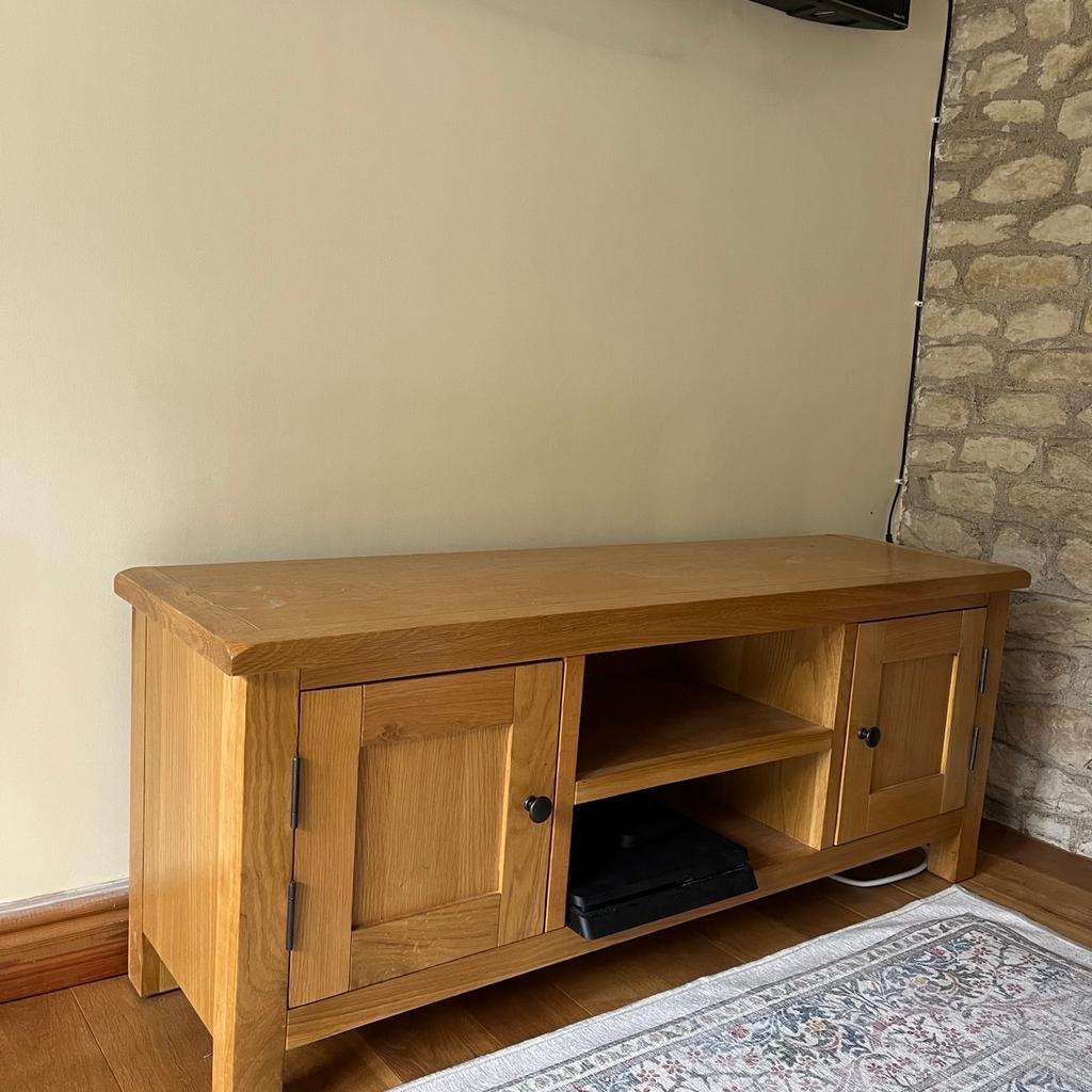 Wooden TV stand/console. In good condition with a couple of marks on the top. Two sections with doors for good storage as well as two shelves in the middle for Sky Box/Games Console. Two holes in the rear of the unit for plug/wires.