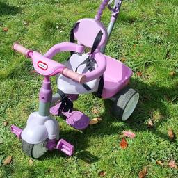 Little Tikes purple ride on trike.

Handle to push.

Comes with a sun shade that clips on, and also you can remove part of it as the child grows (the part that holds them in!).  Has straps to secure them in.