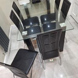 Modern black leather dining table with 6 chairs with glass top. 150cm length 89cm width. height 78cm. like new. no longer required. collection only