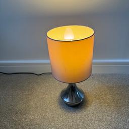 Table / bedside lamp, touch base to turn on or off.

Comes with spare bulb.
