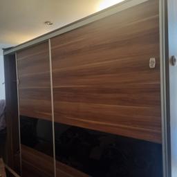 large brown wardrobe with sliding door.