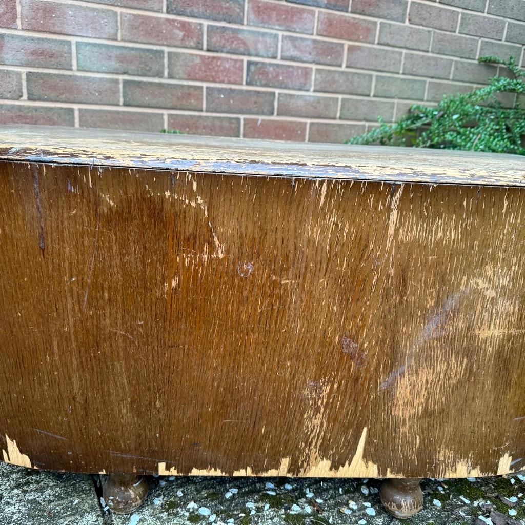 Antique, solid wood ottoman/storage chest. Interior is in good condition although metal chain that attaches chest to the lid is broken. Outside is veneered mahogany wood, which is chipped in places. The ottoman rests on four feet. It would be good for a renovation or up-cycling project.