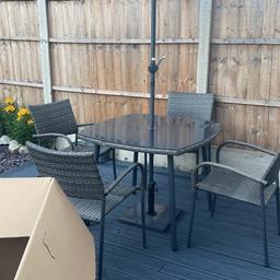 Garden rattan effect patio set with 4 matching chairs, glass table top, umbrella with base weight, in good condition, kept in shed during winter. This set is being sold in argos currently at £300 ( photo attached of argos advert)