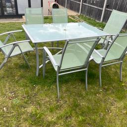 Glass and aluminium pale green table and 6 chairs 2 that recline. Comes with parasol base (parasol not included) and tea light holders. Must collect from Watford area