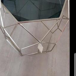Invest in understated elegance with the palm luxe occasional table. Dimensions 50 cm x 40 cm approx,
smokey glass top with stainless steel frame,
beautiful modern and stylish hexagon shape,

never used
tags still attached
bought before decorating nd doesnt fit where I needed it
no offers
£60 new
collection only or can deliver locally for small fee