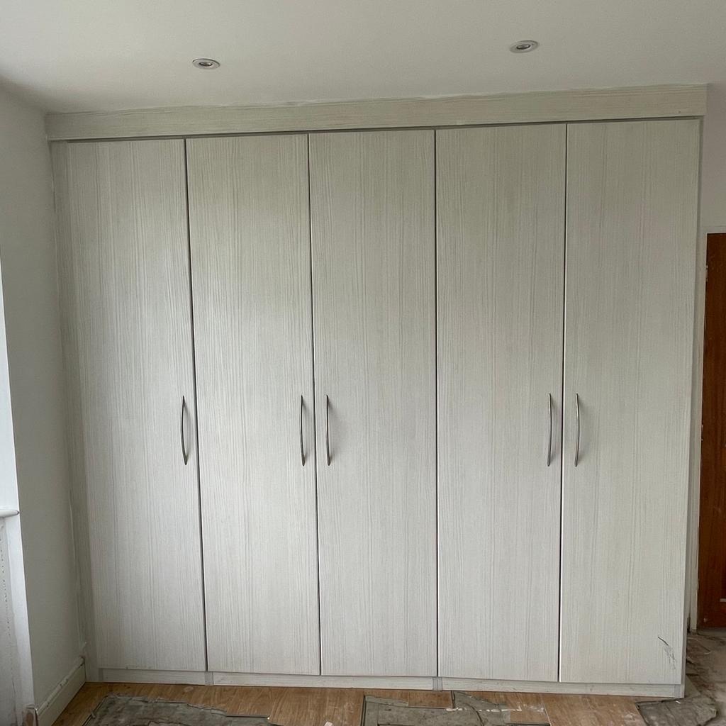 This bedroom set consists of:

- A five door wardrobe measuring 245cm high and 250cm wide (height can be adjusted by trimming the top plinth), divided into three units. Each unit contains a hanging rail and top shelf, whilst the middle unit also includes a chest of three drawers.

- Two single door wardrobes measuring 245cm high and 45cm wide (height can be adjusted by trimming the top plinth) containing multiple shelves.

- Two bedside cabinets approx 45cm wide.

The units are solid and very clean inside. The outside is also in great condition but could do with a good clean.

Please note that these are fitted wardrobes so do not have a back or a floor as they are meant to

be screwed into the walls and floor.

Buyer to dismantle and collect.

Only selling as recently bought house and want to put our own stamp on it.