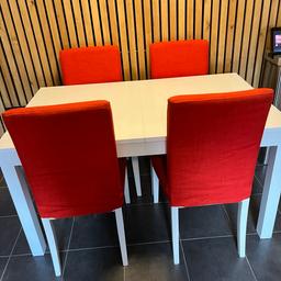 White extending table and 4 chairs with orange chair cover and another set of cover with green leave pattern. Very good condition