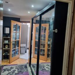 large black wardrobe. with hanging and shelfs and two glass sliding door.
very good good storage capacity and strong.