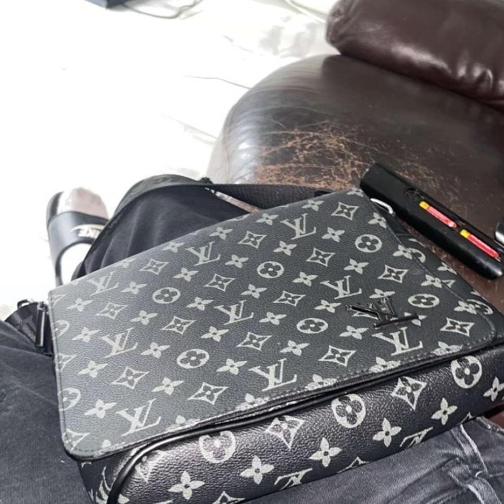 Elevate your style game with this high-quality messenger bag from the iconic brand, LV. Crafted for the sophisticated man on-the-go, this bag boasts of a sleek design and ample space to accommodate all your essentials. The bag is perfect for work or play, and is sure to add a touch of elegance to your outfit.

Designed with the modern man in mind, this messenger bag features a sturdy strap for comfortable wear and is made from premium materials to ensure durability. Ideal for men who appreciate quality, this bag is a must-have for anyone looking to make a fashion statement.