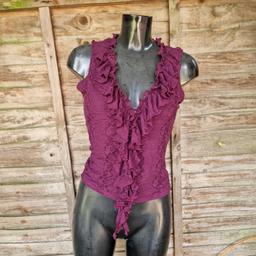 Size 14 stretchy top. Maroon floral lace. Sheer back, lined front. Ruffled neckline and draping down the front. Low v-neck. 
Brand label has been removed. 
Chest measures 36"
Length 19"
99% nylon 1% elastene