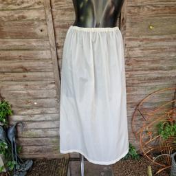 Vintage 1980s/1990s midi maxi length slip underskirt. Sheer cream fabric. Elasticated waistband. Cut out back section. No give to fabric. 
Label says size 16
Waist measures 24"-36"
Hips measure 44"
Length 31.5"
Polyamide