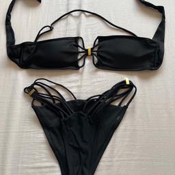 Black bandeau style bikini with removable and adjustable halter strap, and high leg bottoms. Bought online, but tags removed so unsure of retailer. 
Size is small.
Hardly worn but the metal bits are starting to tarnish a bit, but otherwise it’s still in good condition.