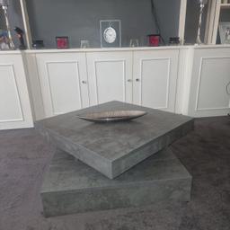 Brand New Dark Grey Designer Block Coffee Table. 80cm x 80cm. Visually looks like stone concrete. Table has a circular mechanism that allows it to twist to any desired shape as seen in photos. Looks expensive and modern. Bought for £219 a few weeks ago selling for £100 for quick sale.
Comes in original box with all instructions and tools / screws and fixtures for assembly.

PLEASE NOTE There is slight cosmetic damage to 2 edges as seen in photo, hardly noticeable when built