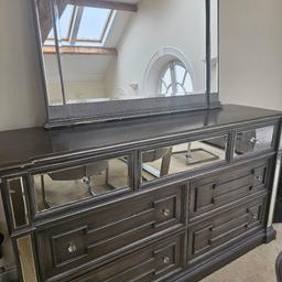 Stunning Grey/Silver mirrored Sideboard and Mirror. 
Both are seperate pieces
7 Mirrored drawers.
Was very expensive when bought. 
Some scratches on corners but can be refurbished or painted.
Sideboard is L65 inch x Height 36.5inch
Mirror is 45inch x 45inch