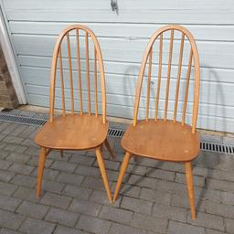Two sturdy blonde Ercol Quaker Windsor dining chairs having the early blue label dating from around the 1960s/1970s and in good vintage used condition showing some signs of daily use and slight cracking to the hoops.