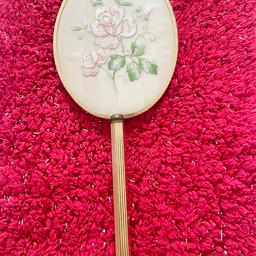 This vintage hand held vanity mirror is a beautiful addition to any collection. 
Made in England, it features a stunning golden frame with a delicate pink rose design. Measuring at 12.5 inches, this mirror is heavy and well-crafted.
Perfect for any vanity, this mirror is sure to add a touch of elegance to your routine. 
Its intricate design and high-quality materials make it a great display piece as well. 
Don't miss your chance to own this gorgeous vintage mirror.
Offers welcome
