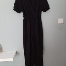black boohoo jumpsuit , pockets on either side , low cut elasticated at ankles and sleeves