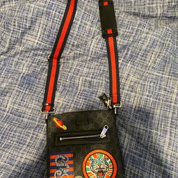 Worn a few times but still in good condition, black messenger bag with red strap and graphics on the front