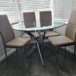 Glass round dinning table with chrome legs. Dimension: 1m

4 beige chairs (1 or 2 have very small defect behind the chairs or by the side, which are hardly visible, shown in picture) and some have light pen marks.