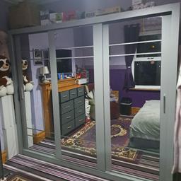 3 door Mirrored Sliding doors wardrobe colour grey two end ones are hanging and a shelf on top and the middle one is 4 shelfs great condition large size