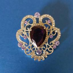 PRETTY BROOCH..
NEW CONDITION.
SYMTHETIC PURPLE STONE..
SPARKERLY IN THE LIGHT..
EASY OPEN / CLOSE CLASP.
COMES ON A VOILE GIFT BAG....
