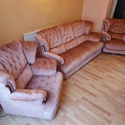 Soft pink grooved cloth 3 piece sofa suite. comprises x2 single seat arm chairs & x1 three seat sofa. very comfortable and generally in good condition. the defects are that one wheel base on each single seater will need attention, and one seat has listed to one corner. there are also 2 marks on the back of the three seater