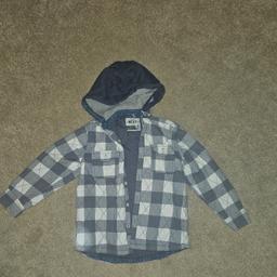Next
Grey. White. Blue
Hooded
Checked
Square pattern
Long Sleeve
Shacked
Button Up 
Pockets
Age 5-6 years
very good condition