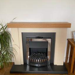 Freestanding fireplace with full surround and remote control. 2 heat settings and real smoke when orange filter filled with water at the bottom. Just plugs in to the mains using a normal plug. Also comes with a choice of coal or log decorations