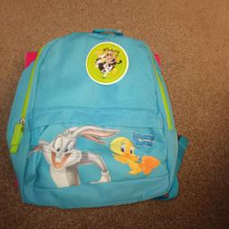 Never been used - Tag still attached - Kids or Adults - Blue - Bugs Bunny and Tweetie Pie - Main zip opens to main bag area and inner zipped pocket - Zip pocket on the front - Adjustable straps.