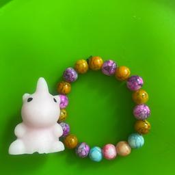 multicoloured handmade glass bead bracelet with a small unicorn mochi squishy