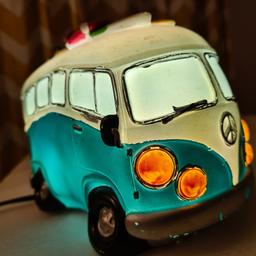 VW CAMPER VAN ELECTRIC TABLE BED NIGHT LAMP -Turquoise.

1960's inspired split-window kombi camper van table lamp. Made with a combination of polyresin and fibreglass makes for a smooth and shiny surface that emits a soft glow from inside. Perfect for the 1960's collector or Kombi fan.

223(L) x 118(W) x 116(H) mm.

On/off switch on the power cable.

Add some quirkiness to your living space with this electric table lamp featuring a vintage-style VW camper van. Great as a night lamp for children, adults as well as pets.

This has been PAT, so electrically safe.

Made of durable plastic, this table lamp is perfect for adults and children. Ideal for any room, this fun and curiosity-themed lamp is sure to be a hit with fans of the iconic VW camper van.

Can also be used in a themed cafe/ restaurant, as any VW enthusiast would appreciate but you will be the envy if you had a campervan, and sharing this in the outdoor with others.

Choice is yours, so you make the magic happen today!