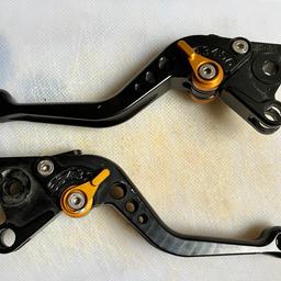 Set of used Pazzo Racing shorty clutch & brake levers for Aprilia RSV1000 Mille 1998-2003 in good condition only real blemish of note is to the brake adjuster (see photos). RRP c. £160.

Pazzo Racing Clutch and Brake Levers are CNC Machined of 6061-T6 billet aluminium to precise tolerances. Both clutch and brake levers are fully adjustable. Stainless steel fasteners and cadmium plated custom made springs.

Pazzo Racing Lever is a position adjustable lever. The miniature "clicker" lever controls a roller cam assembly, giving riders the ability to change lever position while riding. Brake fade and clutch adjustments can be taken care of easy!

Pazzo Racing Brake & Clutch Levers Key Features:

- Adjustable on the move
- Great range of adjustment plus 'dog-leg' design for greater comfort
- Easy, direct replacement to standard levers
- Proven on the race track
- Shorty lever is much less likely to get damaged in a crash