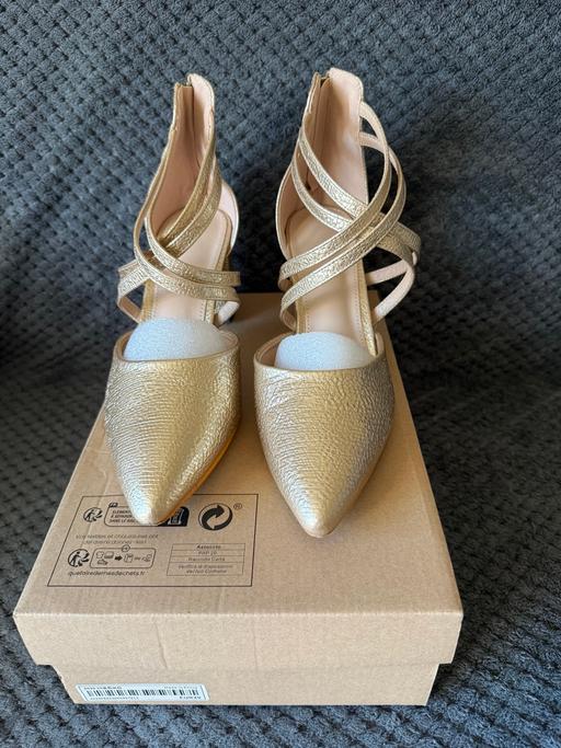  — Womens gold strappy shoes.