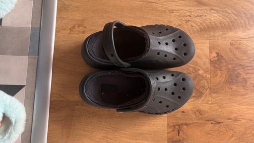  — Black platform fur lined crocs.
