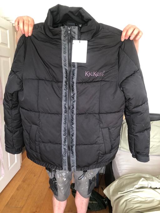  — Kickers black man’s black medium coat.