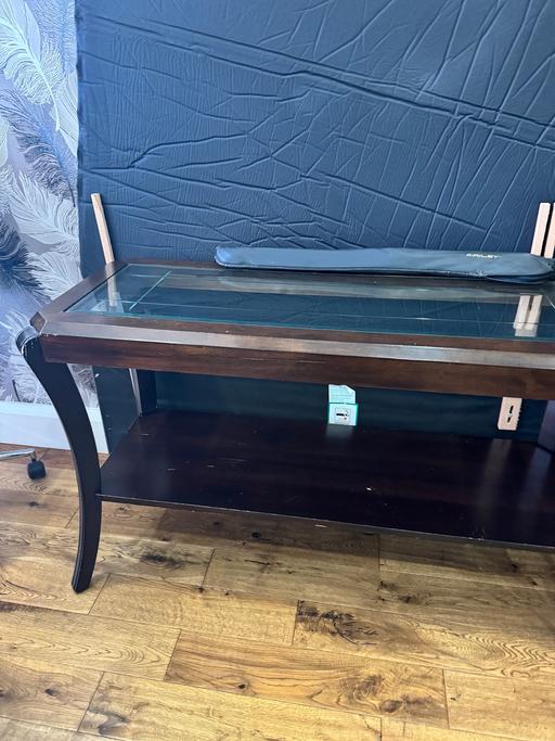  — dark wooden console table with a glass top.