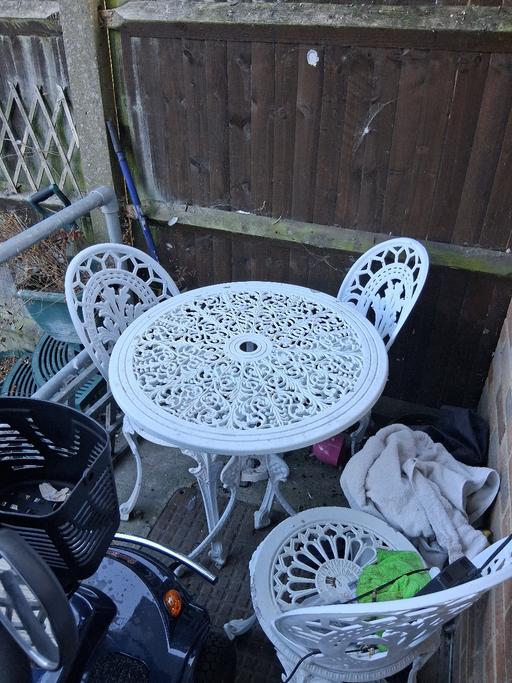  — Cast iron , white table and three chairs gard